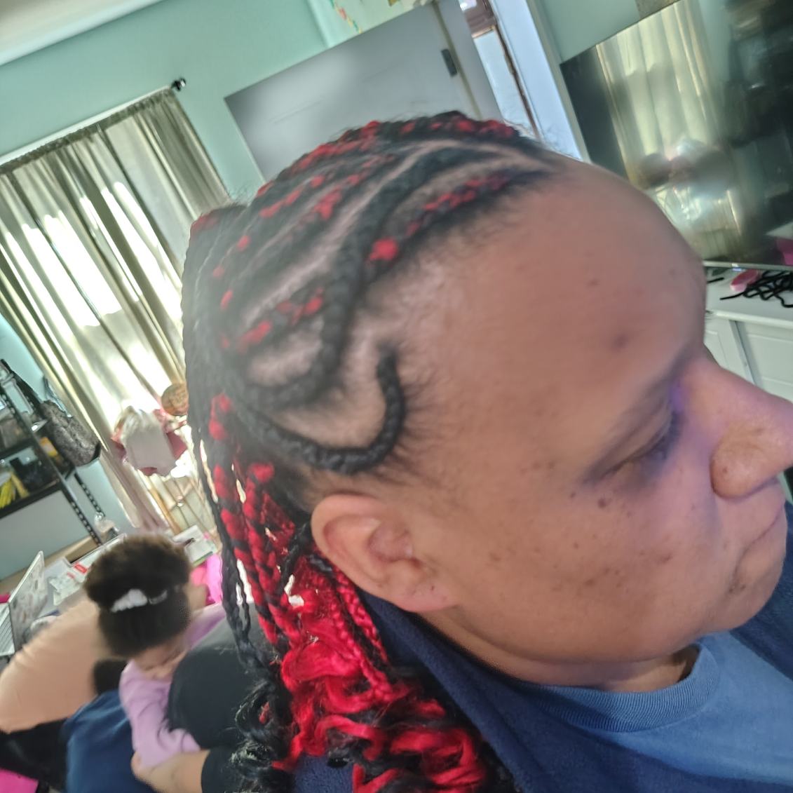 Tight braids with red accents, close up