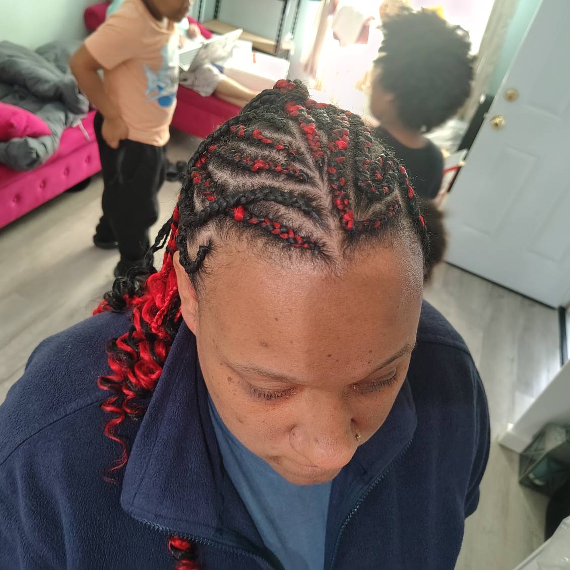 Braids with red and black extensions, styled by Jazmiane